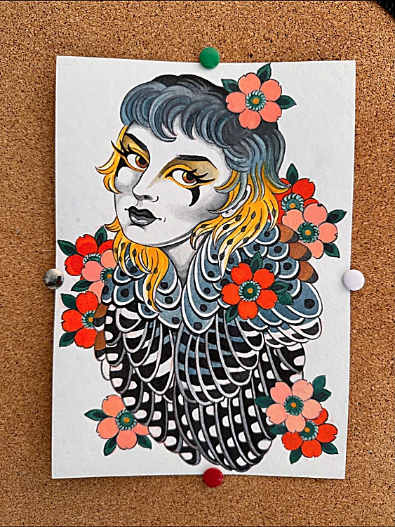 Diseño pintado de una mujer con plumas de cernícalo y flores rojas, clavado en un corcho