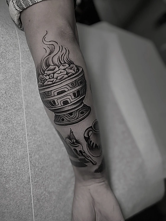Incensario japonés con humo en negro y gris sobre el antebrazo
