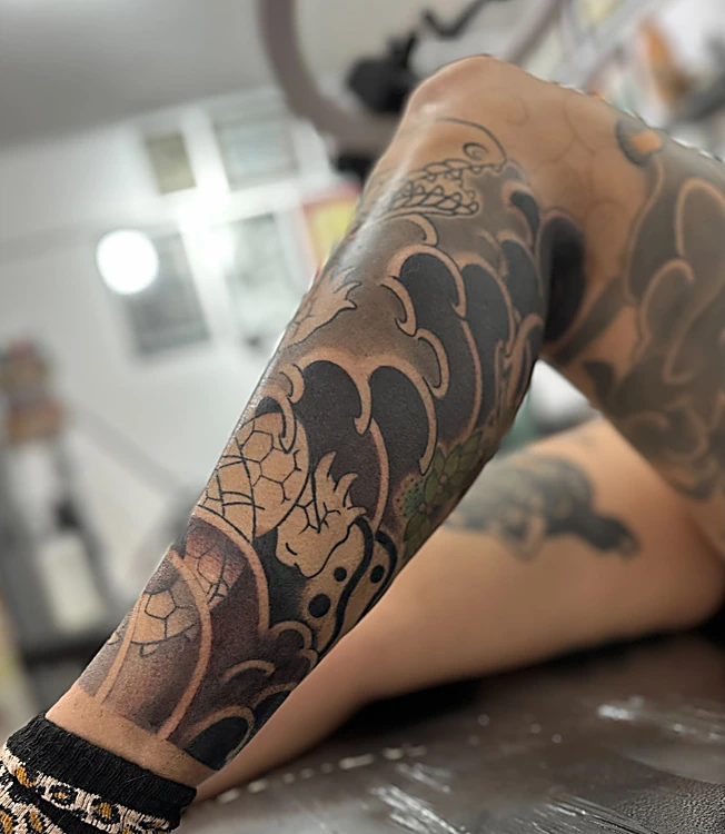 Manga japonesa en negro con nubes y viento sobre el antebrazo, en proceso
