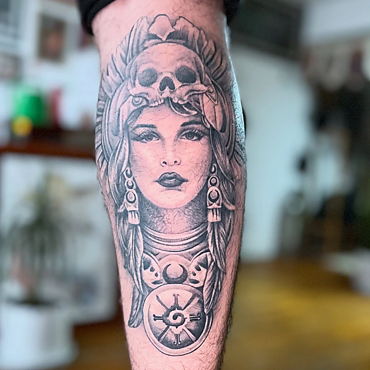 Mujer con tocado de calavera y joyería, en negro y gris sobre el antebrazo